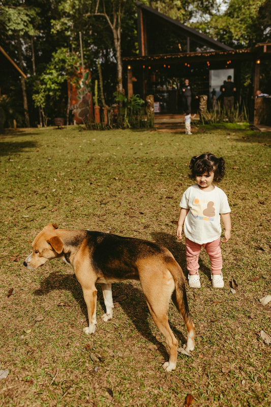 A dog and a child play outdoors together.